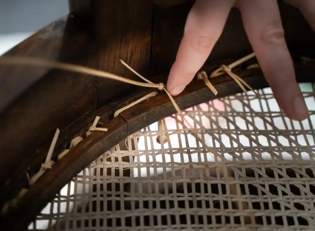 Photo montrant les noeuds en cannage traditionnel qui sont caché sous l'assise. 